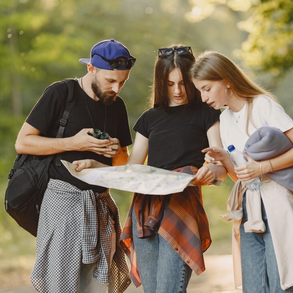 people hiking and discussing location on paper map